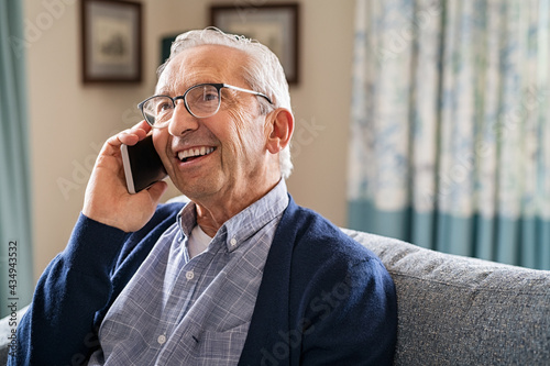 Happy carefree old man talking over phone