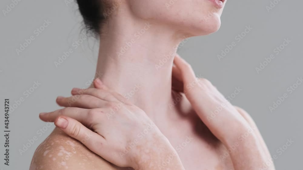 A cropped view of an attractive half naked woman is touching her skin while posing to the camera standing isolated over gray wall in the studio. Diversity tolerance. Every body is beautiful A cropped view of an attractive half naked woman is touching her skin while posing to the camera standing isolated over gray wall in the studio. Diversity tolerance. Every body is beautiful