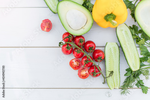 Fresh vegetables, onion, avocado, carots, tomatoes, cucumber, greenary on white background