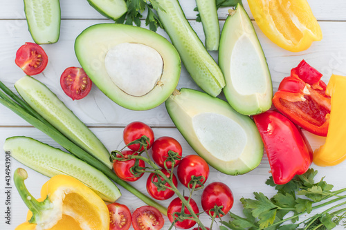 Fresh vegetables, onion, avocado, carots, tomatoes, cucumber, greenary on white background