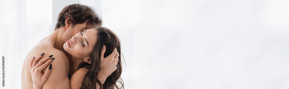 Young muscular man kissing and touching hair of sexy girlfriend, banner Young muscular man kissing and touching hair of sexy girlfriend, banner
