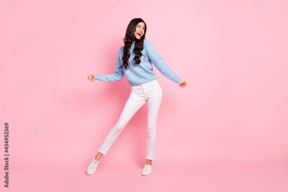 Full size portrait of carefree charming girl look empty space partying isolated on pink color background Full size portrait of carefree charming girl look empty space partying isolated on pink color background