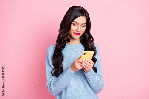 Photo of charming positive girl look phone typing comment wear sweater isolated on pink color background