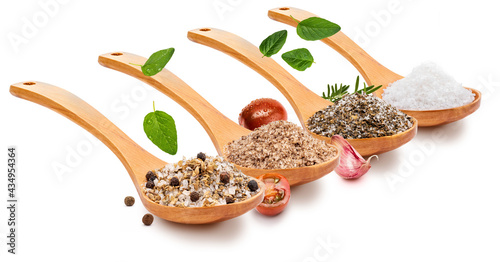 Fototapeta Naklejka Na Ścianę i Meble -  Variety of salt (salts) with various spices (tomato, garlic, oregano, rosemary, black pepper) in wooden spoon (variety of salt collection). Isolated on white background. Rustic appearance.