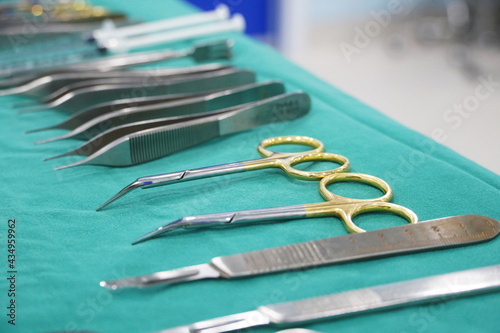 Surgical instruments, surgery, placed on a sterile green cloth, soft focus                               