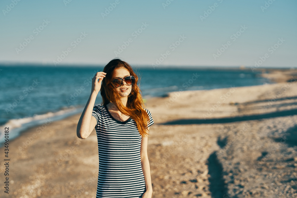 a traveler in a striped t-shirt is resting on the beach near the sea in the summer in the mountains a traveler in a striped t-shirt is resting on the beach near the sea in the summer in the mountains