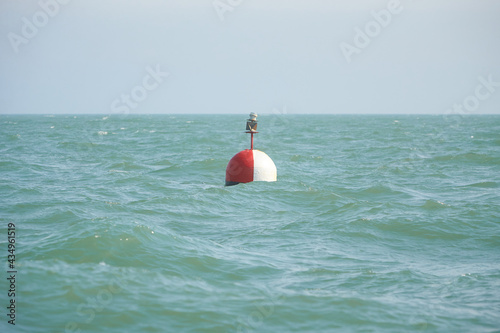 A marker buoy floating in the sea. beacon. Sunny late autumn afternoon.  photo