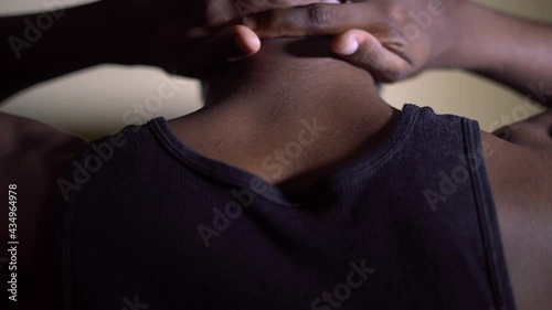 African American male surrendering to police office with his hands behind his head while police siren flashes in the background concept. 
