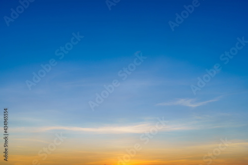 Twilight blue bright and orange yellow dramatic sunset sky in countryside or beach colorful cloudscape texture with white clouds air background. © Thinapob