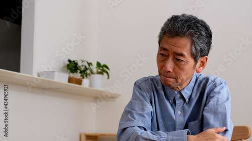 悩んで困っているシニア男性