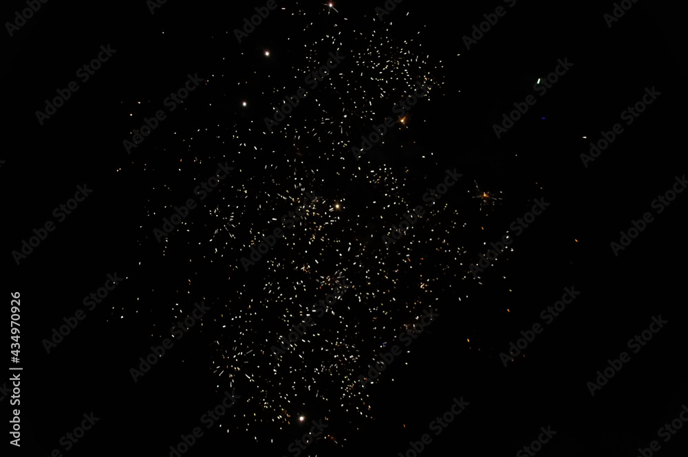 Fireworks display at night in a dark sky and golden sparks. Abstract background from pyrotechnic. Firework explosion in the sky for celebrations and festivals.