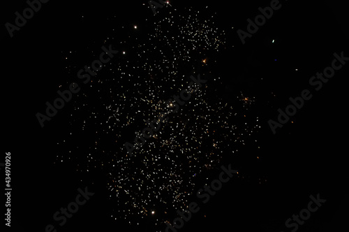 Fireworks display at night in a dark sky and golden sparks. Abstract background from pyrotechnic. Firework explosion in the sky for celebrations and festivals.