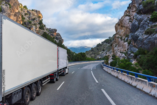 Mega truck or euro modular system (EMS) with refrigerated semi-trailers driving through a gorge. photo