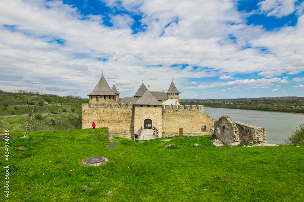 View of old castle Hotin near the river. Khotyn Fortress - medieval castle on yellow autumn hills. Ukraine, Eastern Europe. The architecture of the Middle Ages in our time.