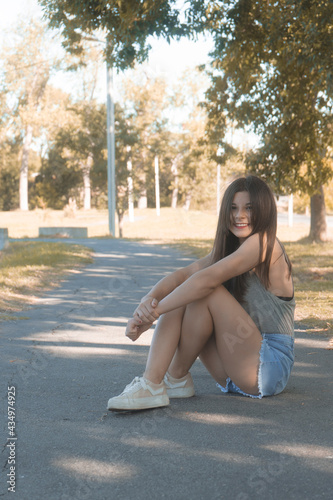 Beautiful Asian girl wearing a crop top and a jean skirt posing for the camera at the park