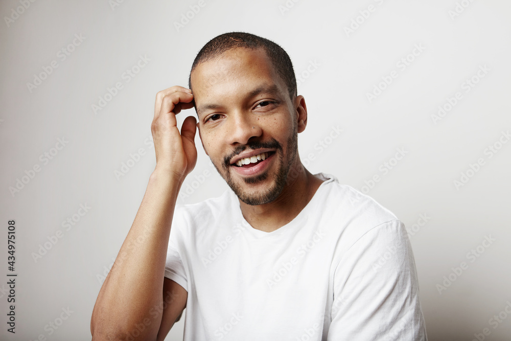 Black young man wears white t-shirt posing isolated in studio.