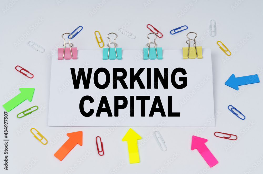 On the table there are paper clips and directional arrows, a sign that says - Working Capital On the table there are paper clips and directional arrows, a sign that says - Working Capital