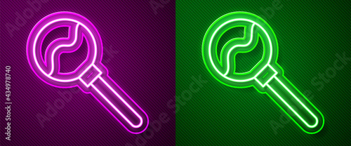 Glowing neon line Lollipop icon isolated on purple and green background. Food, delicious symbol. Happy Halloween party. Vector