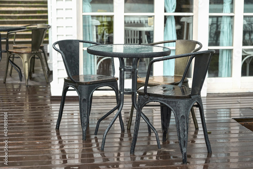 A table on the veranda of a summer cafe in the rain. Selective focus. © ROMAN DZIUBALO