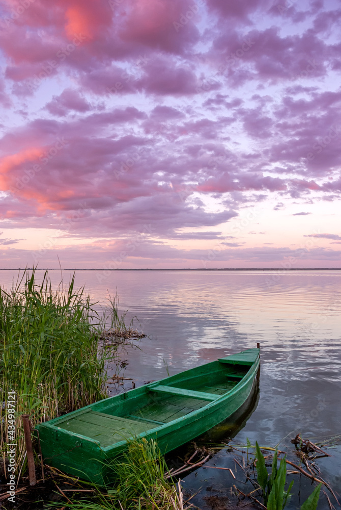 Beautiful landscape with boats on the lake and clouds in the sunset sky. Beautiful landscape with boats on the lake and clouds in the sunset sky.