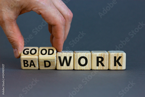 Good or bad work symbol. Businessman turns wooden cubes and changes words 'bad work' to 'good work'. Beautiful grey background, copy space. Business and good or bad work concept.