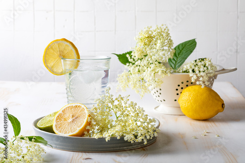 Canvas Print Glass of homemade elderflower lemonade with lemon, lime juice and freshly picked elderberry flowers