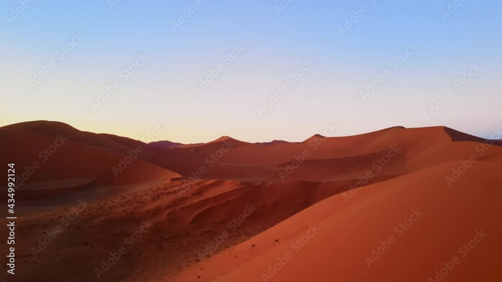 Drone shot from great height of dunes in african desert. Aerial view on tall sand hills in barren wilderness and plain of sand inbetween. Beautiful natural landscape of massive barchan shot by drone. Drone shot from great height of dunes in african desert. Aerial view on tall sand hills in barren wilderness and plain of sand inbetween. Beautiful natural landscape of massive barchan shot by drone.