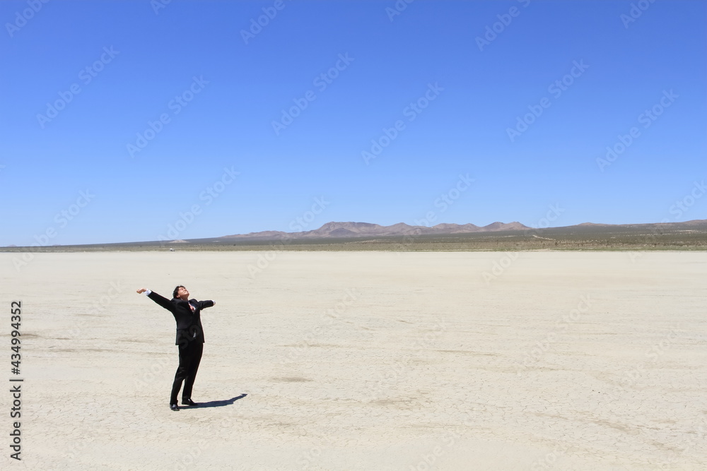 Young businessman stretching in the vast desert