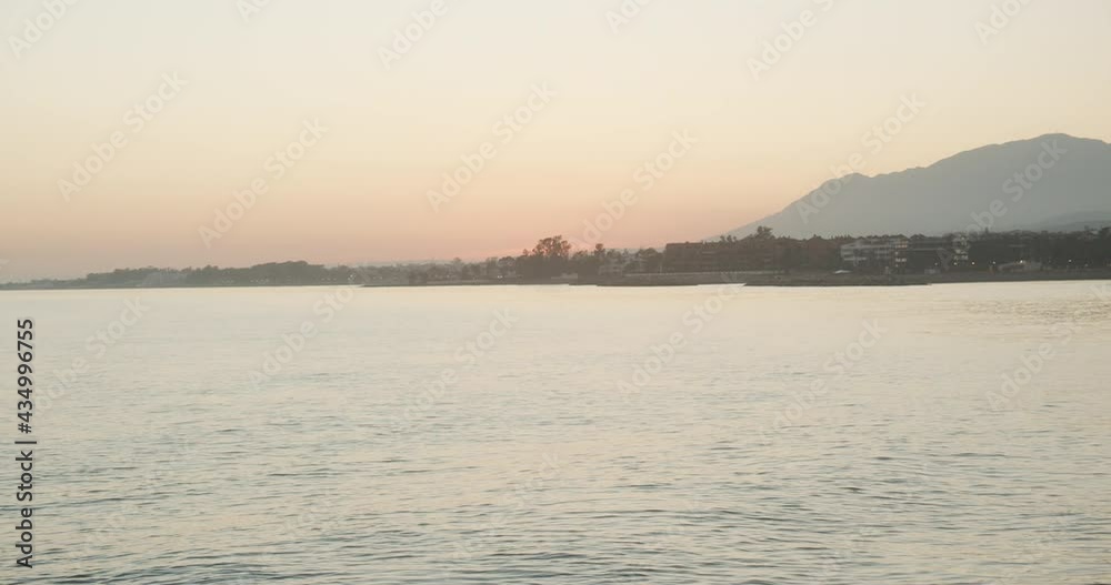 Woman Watching Sunset Over Sea And Coastline Woman Watching Sunset Over Sea And Coastline