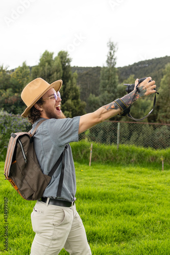 travel blogger with camera glasses and backpack in nature with a happy expression vertical photo 