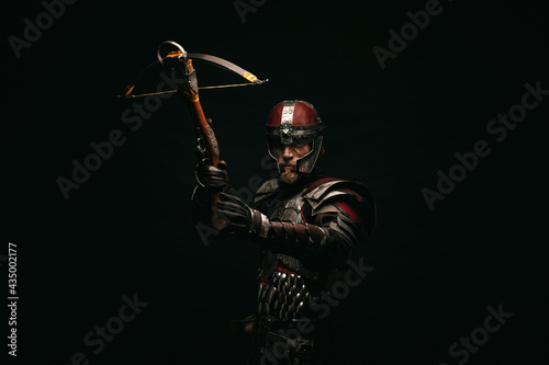 Photo Portrait of a medieval fighter holding a crossbow in his hands