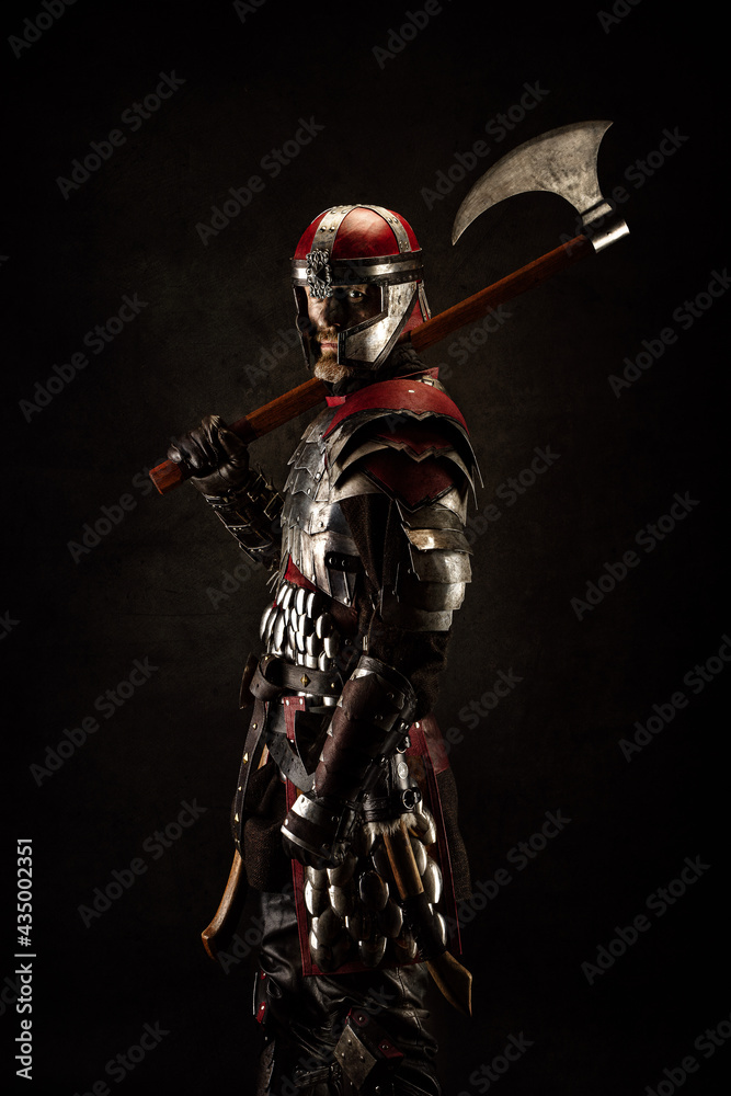 Naklejka premium Portrait of a medieval fighter carrying an ax over his shoulder