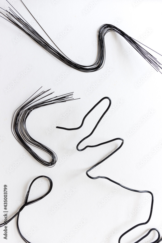 various crafting wire (painted black) on white - photographed from above in flat lay composition