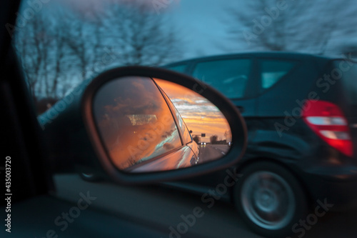 Sunset Landscape Reflected in Car Wing Mirror at Dusk
