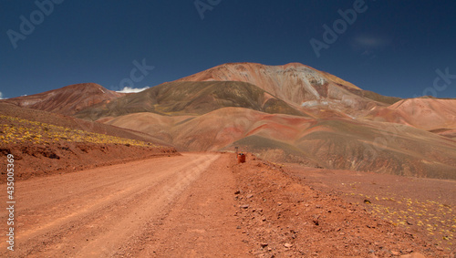 The dirt road high in the Andes mountains. Traveling along the route across the arid desert dunes and mountain range. The sand and death valley under a deep blue sky in La Rioja, Argentina.
