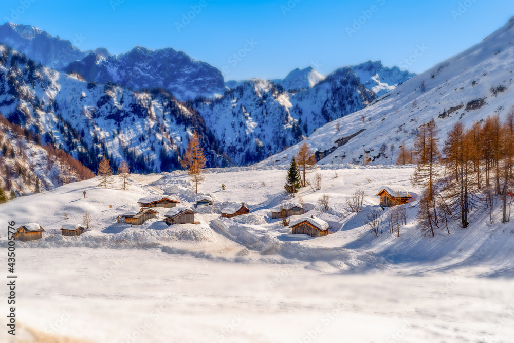 Snowy landscape with small snowy mountain huts in valley. Dolomites, Italy . Tilt-Shift Effect Snowy landscape with small snowy mountain huts in valley. Dolomites, Italy . Tilt-Shift Effect