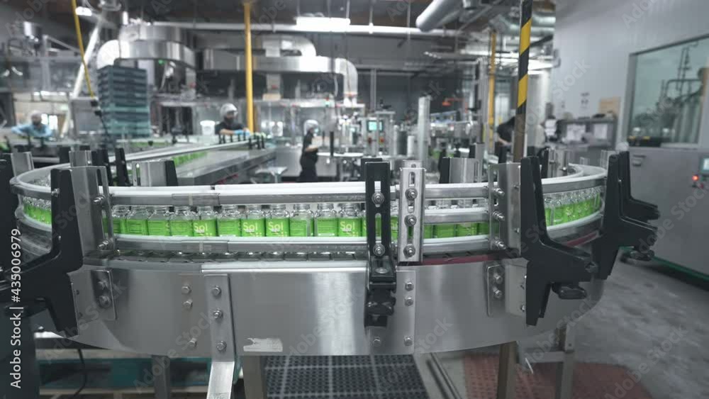 Robotic factory line for processing and bottling juice bottles. Production automation line. Beverage factory interior. Robotic factory line for processing and bottling juice bottles. Production automation line. Beverage factory interior.