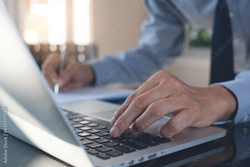 Businessman busy working on laptop computer and business document in office Businessman busy working on laptop computer and business document in office