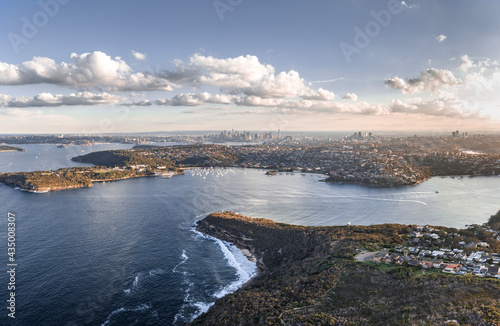 High angle aerial drone view of Balmoral Beach and Edwards Beach in Mosman, Sydney, New South Wales, Australia. CBD, North Sydney and Chatswood in background left to right. Grotto Point in foreground. photo