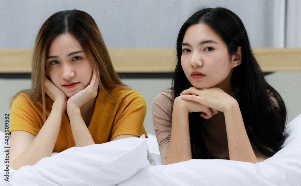Smiling Two Asian young women lovely couple sitting on white bed and happy. Funny women after wake up together on cozy. Concept In love homosexual lesbian lgbt, lgbtq, lgbtq+. Smiling Two Asian young women lovely couple sitting on white bed and happy. Funny women after wake up together on cozy. Concept In love homosexual lesbian lgbt, lgbtq, lgbtq+.