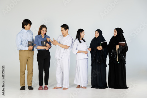 Asian men and women of different religions have Buddhism, Muslims, Christ. bible Quran. A smiling face wearing religious clothes, white background. Concept religious ideas teach love, faith, desire.