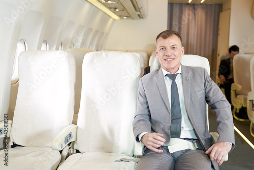 Caucasian businessman sitting in besiness class of airplane for comfortable photo