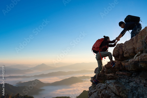 Asia couple hiking help each other on mountains