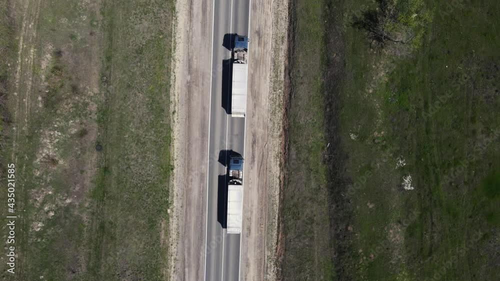 trucks are driving on the motorway. aerial shooting trucks are driving on the motorway. aerial shooting