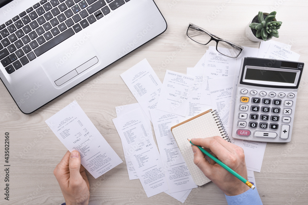 Unrecognizable businessman using calculator on desk office and writing make  note with calculate about cost at home office. finance accounting concept.  tax , shopping, cost management foto de Stock | Adobe Stock