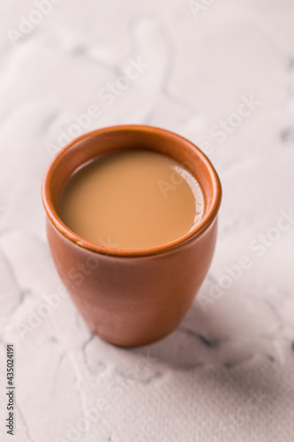 Indian chai in glass cups with metal kettle and other masalas to make the tea.