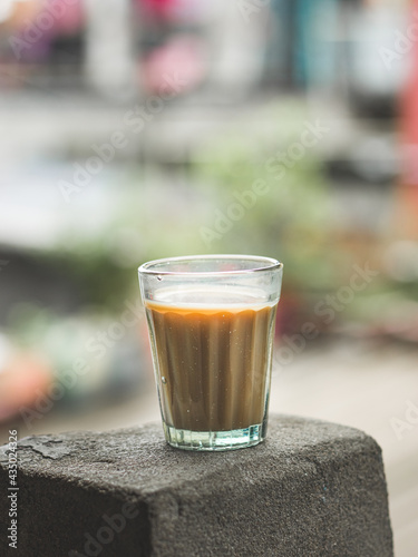 Indian chai in glass cups with metal kettle and other masalas to make the tea.