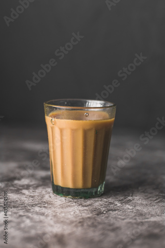 Photography Indian chai in glass cups with metal kettle and other masalas to make the tea