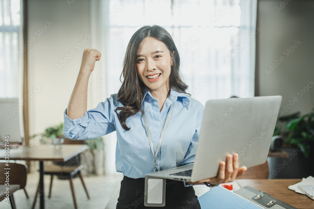 Asian girl celebrate with laptop. successful businesswoman in office Asian girl celebrate with laptop. successful businesswoman in office