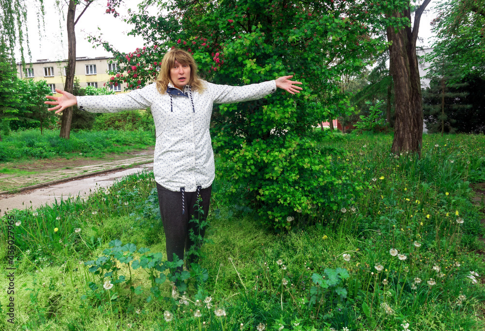 mature woman, middle-aged, pretty with blond hair, positive, cheerful, outdoors, resting, stretched out her arms in surprise mature woman, middle-aged, pretty with blond hair, positive, cheerful, outdoors, resting, stretched out her arms in surprise